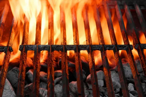 Flames rising inside a BBQ grill